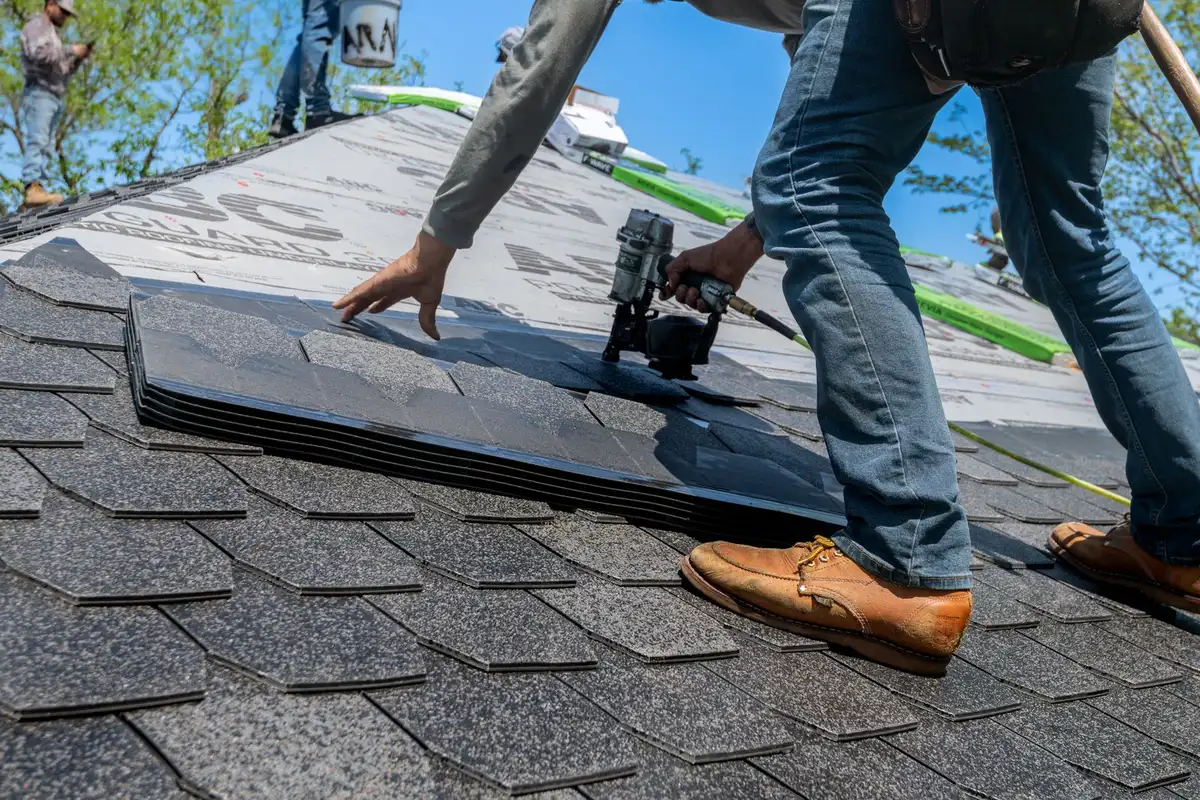 A roofer installing shingles on a Sherman, TX home